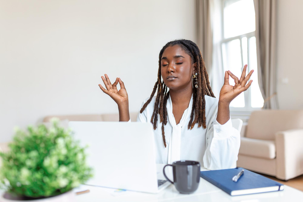 Femme méditant devant un ordinateur